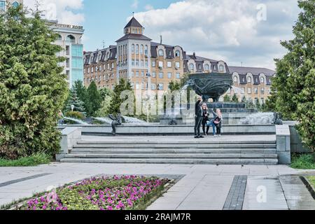 Kasan, Russland - Juni 8. 2023: Platz mit einem Brunnen in Form einer Schüssel - Kessel im Millennium Park. Die Familie macht ein Selfie vor dem La Stockfoto