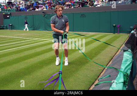 Das Bodenpersonal zieht die Regendecke heraus, während am zweiten Tag der Wimbledon-Meisterschaft 2023 im All England Lawn Tennis and Croquet Club in Wimbledon der Regen stoppt. Bilddatum: Dienstag, 4. Juli 2023. Stockfoto