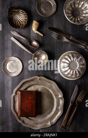 Verschiedene antike Gerichte im Vintage-Stil auf schwarzem Tafelbrett. Flach verlegt. Draufsicht. Speisekonzept. Dunkle Stimmungsfotografie. Stockfoto