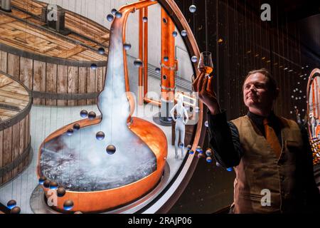 Reiseleiter mit einem Glas Whisky bei einer beeindruckenden Medienprojektion über Whisky-Brauen, Scotch Whisky Experience, Edinburgh, Schottland, Großbritannien Stockfoto