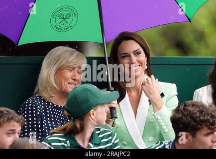 Die Prinzessin von Wales unter einem Schirm mit Deborah Jevans vor dem Regen spielt im Spiel zwischen Katie Boulter und Daria Saville am zweiten Tag der Wimbledon Championships 2023 im All England Lawn Tennis and Croquet Club in Wimbledon. Bilddatum: Dienstag, 4. Juli 2023. Stockfoto