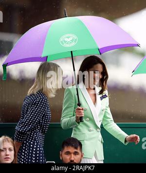 Die Prinzessin von Wales verlässt den Hof unter einem Schirm mit Deborah Jevans und Laura Robson, nachdem das Spiel zwischen Katie Boulter und Daria Saville am zweiten Tag der Wimbledon-Meisterschaft 2023 im All England Lawn Tennis and Croquet Club in Wimbledon unterbrochen wurde. Bilddatum: Dienstag, 4. Juli 2023. Stockfoto