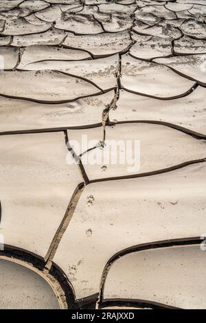 Dürre in Afrika in einem Fluss. Dramatisch zerrissene Schlammerde in einem trockenen Flussbett in Afrika. Swakop River, Namibia, Afrika Stockfoto