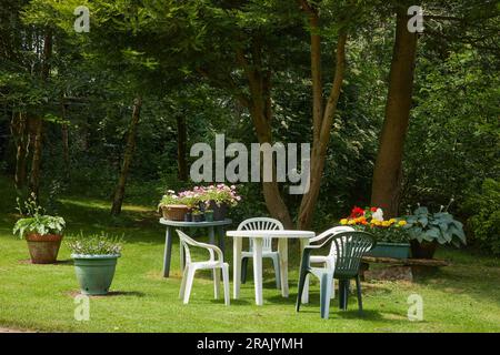 Ein sonniger Juni-Tag und Gartenmöbel aus Plastik auf einem Rasen im kleinen Garten des Moorlands. North Yorkshire Stockfoto