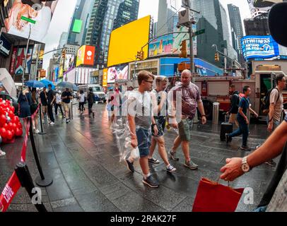In Plastik verpackte Touristen in einem regnerischen Times Square in New York am Dienstag, den 27. Juni 2023. © Richard B. Levine) Stockfoto