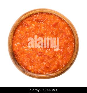 Ajvar, genießen Sie aus gerösteten Paprika, in einer Holzschüssel. Gewürze, Brotaufstrich und Beilage, beliebt auf dem Balkan. Stockfoto