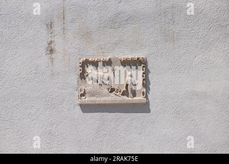 Koper, Slowenien. 2. Juli 2023. Ein Relief, das einen Bauern mit einem Pflug an der Fassade eines Gebäudes im Stadtzentrum darstellt Stockfoto