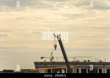 Der Kran, der bei Sonnenaufgang Güter nach oben transportiert. Stockfoto