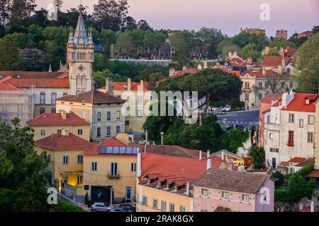 Das historische Stadtzentrum rund um das Camara Municipal de Sintra oder Rathaus, ein Burgbau mit einem Turmdach und Uhrenturm, bei Sonnenuntergang in Sintra, Portugal. Die romantischen architektonischen und märchenhaften Paläste ziehen Touristen aus der ganzen Welt an. Stockfoto