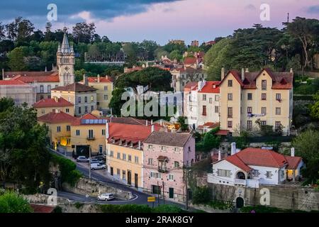 Das historische Stadtzentrum rund um das Camara Municipal de Sintra oder Rathaus, ein Burgbau mit einem Turmdach und Uhrenturm, bei Sonnenuntergang in Sintra, Portugal. Die romantischen architektonischen und märchenhaften Paläste ziehen Touristen aus der ganzen Welt an. Stockfoto