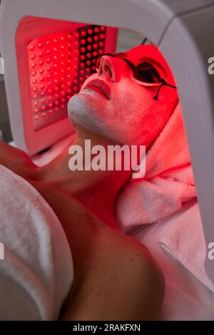 Eine Frau, die eine Gesichtsbehandlung mit LED-Therapie erhält. Stockfoto