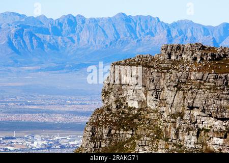 Die Aussicht vom Gipfel des Tafelbergs an einem schönen Wintertag. Auch Blick auf die Rückseite des Tafelbergs aus einem Park in Kapstadt. Stockfoto