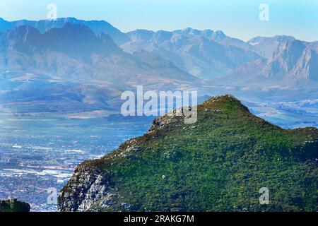 Die Aussicht vom Gipfel des Tafelbergs an einem schönen Wintertag. Auch Blick auf die Rückseite des Tafelbergs aus einem Park in Kapstadt. Stockfoto