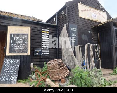 Walberswick, Suffolk - 3. Juli 2023 : warmer Sommernachmittag. Die Fischfabrik Sole Bay im Hafen von Southwold. Spezialangebote für frischen Fisch. Stockfoto