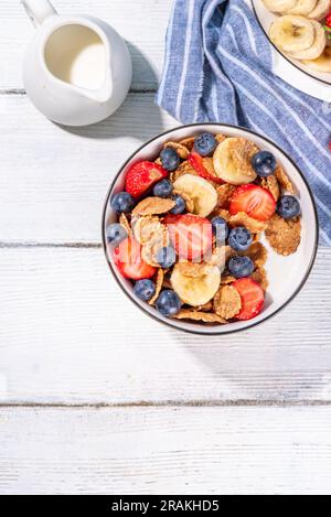 Gesunde Vitamindiät Sommerfrühstück. Cornflakes mit mehreren Körnern, Joghurt oder Milch und Erdbeeren, Blaubeeren, auf dem Küchentisch Kopierraum Stockfoto