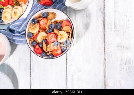 Gesunde Vitamindiät Sommerfrühstück. Cornflakes mit mehreren Körnern, Joghurt oder Milch und Erdbeeren, Blaubeeren, auf dem Küchentisch Kopierraum Stockfoto