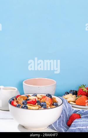 Gesunde Vitamindiät Sommerfrühstück. Cornflakes mit mehreren Körnern, Joghurt oder Milch und Erdbeeren, Blaubeeren, auf dem Küchentisch Kopierraum Stockfoto