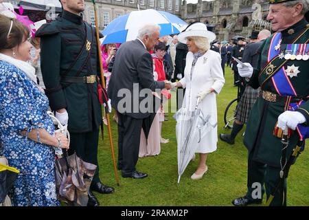 Königin Camilla begrüßt Gäste während einer Gartenparty im Palace of Holyroodhouse in Edinburgh, als Teil der ersten Holyrood Woche seit der Krönung des Königs. Bilddatum: Dienstag, 4. Juli 2023. Stockfoto