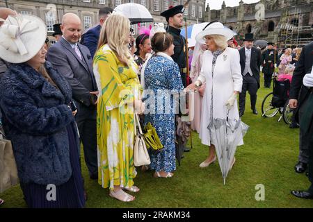 Königin Camilla begrüßt Gäste während einer Gartenparty im Palace of Holyroodhouse in Edinburgh, als Teil der ersten Holyrood Woche seit der Krönung des Königs. Bilddatum: Dienstag, 4. Juli 2023. Stockfoto