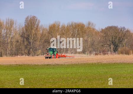 Ländliche Szene mit einem Traktor, der ein Feld mit einem Pflug in der Wintersonne pflückt Stockfoto