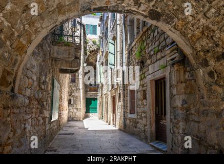 Eine typische überdachte, enge Gasse in der mittelalterlichen Altstadt neben den Mauern des Diokletianpalastes in Split, Dalmatien, Kroatien. Stockfoto