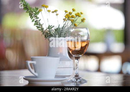 Ein Glas Prosecco und eine Tasse Kaffee auf dem Tisch im Café Stockfoto