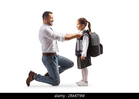 Profilaufnahme über die gesamte Länge eines Vaters, der einem Mädchen hilft, sich auf die Schule vorzubereiten, isoliert auf weißem Hintergrund Stockfoto