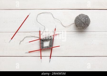 Der Strickvorgang im Kreis auf doppelseitigen Stricknadeln, Garnknäuel. Stockfoto