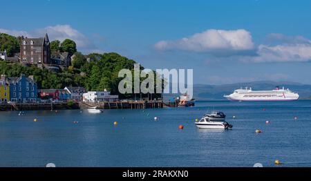 Tobermory, Isle of Mull, Schottland, Vereinigtes Königreich. 6. Juni 2023 Kreuzfahrtschiff vor Anker auf dem Sound of Mull jenseits der Küstenstadt Tobermory. Stockfoto