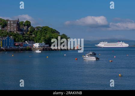 Tobermory, Isle of Mull, Schottland, Vereinigtes Königreich. 6. Juni 2023 Kreuzfahrtschiff vor Anker auf dem Sound of Mull jenseits der Küstenstadt Tobermory. Stockfoto