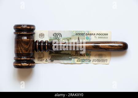 Der Hammer des Richters liegt auf 10 Rubel auf weißem Hintergrund, Recht und Gerechtigkeit, Korruption Stockfoto