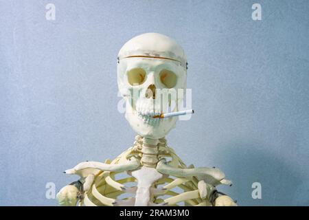 Menschliches Skelett mit einer Zigarette. Kann für eine Anti-Raucher-Kampagne verwendet werden. Stockfoto