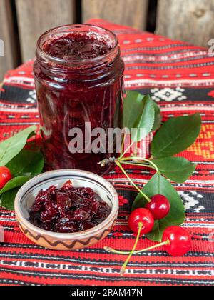 Glas mit hausgemachter Sauerkirschmarmelade Stockfoto