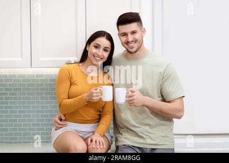 Portrait eines fröhlichen, liebenden jungen lateinamerikanischen Paares, das zusammen Tee trinkt Stockfoto