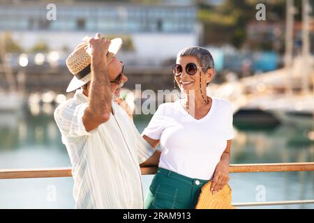 Senior Man Mit Strohhut Umarmt Seine Frau In Marina Outdoor Stockfoto