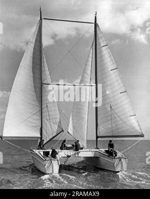 Hampshire, England. 23. Juli 1954 Dieses Segelboot mit Doppelhülle, der EB und der Flo, wird voraussichtlich das schnellste der Welt werden. Das Schiff wurde vom Marinearchitekten Thomas Tothill entworfen und ist nach dem Muster eines Katamarans gebaut, der seine Form wiederum aus Booten zieht, die von den Polynesiern vor Hunderten von Jahren verwendet wurden. Das vier Tonnen schwere Boot, das mit dem Meer fährt, wird nicht umkippen, so der Designer. Es soll den derzeitigen Segelrekord von 23 Knoten angreifen. Stockfoto