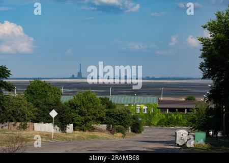 Nikopol, Ukraine. 03. Juli 2023. Nicolas Cleuet/Le Pictorium - UKR - war Ukraine - Kernkraftwerk Zaporijia - Enerhodar - 3/7/2023 - Ukraine/Region Zaporizia/Zaporijia - Kernkraftwerk Zaporizhia - Enerhodar vom rechten Ufer des Dnieper bei Nikopol, mit dem Kakhovka-Reservoir im Vordergrund, Der seit der Zerstörung des Nova Kakhovka-Staudamms Anfang Juni 2023 ausgetrocknet ist. Kredit: LE PICTORIUM/Alamy Live News Stockfoto