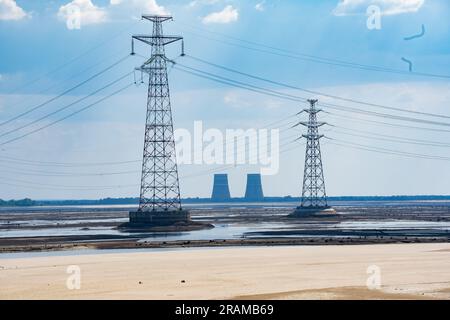 Nikopol, Ukraine. 03. Juli 2023. Nicolas Cleuet/Le Pictorium - UKR - war Ukraine - Kernkraftwerk Zaporijia - Enerhodar - 3/7/2023 - Ukraine/Region Zaporizia/Zaporijia - Kernkraftwerk Zaporizhia - Enerhodar vom rechten Ufer des Dnieper bei Nikopol, mit dem Kakhovka-Reservoir im Vordergrund, Der seit der Zerstörung des Nova Kakhovka-Staudamms Anfang Juni 2023 ausgetrocknet ist. Kredit: LE PICTORIUM/Alamy Live News Stockfoto