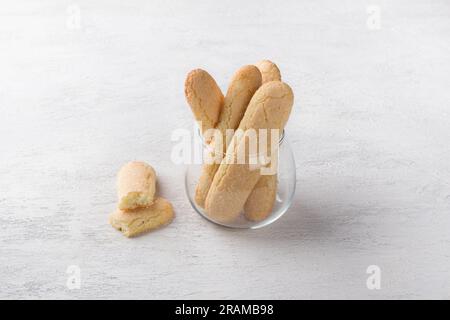 Frisch gebackene hausgemachte savoiardi-Kekse in einem Glasbecher auf einem hellgrauen Tisch. Stockfoto