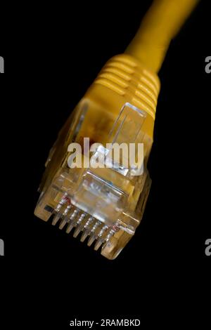 Makrofoto eines gelben 8-poligen ethernet-Steckers auf schwarzem Hintergrund Stockfoto