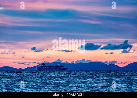 Sonnenuntergang auf dem Meer mit einem Kreuzschiff Stockfoto