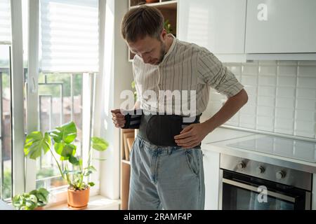 Mann mit Rückenstützkorsett am unteren Rücken zur Behandlung der Hernie, Entlastung der Wirbelsäule. Stockfoto