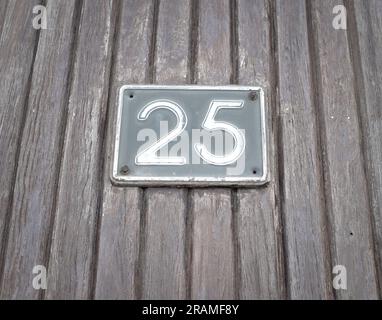 25, Nummer fünfundzwanzig, hellblaue Platte auf den Werftplanken. Stockfoto