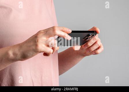 Berlin, Deutschland, Juni 30 2023 Hand hält Handy und sieht sich Video online an. Stockfoto