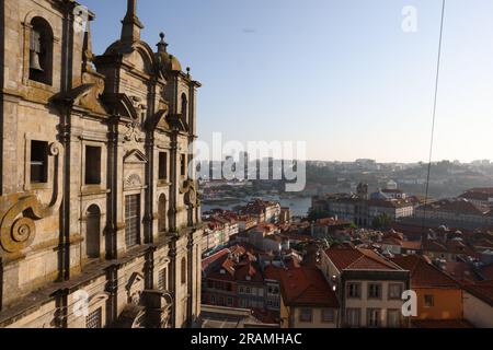 Sonnenuntergang in Igreja dos Grilos, Porto, Portugal. Der Fluss ist in der Ferne umgeben von Schichten historischer Gebäude zu sehen. Stockfoto