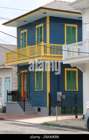 Wunderschönes blaues zweistöckiges kreolisches Cottage mit gelben Zierleisten und grünen Fensterläden, im Viertel Faubourg Marigny, New Orleans. Stockfoto