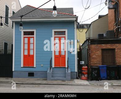 Winziges, malerisches kreolisches Cottage mit leuchtend orangefarbenen Türen im historischen Viertel Faubourg Marigny, New Orleans. Stockfoto