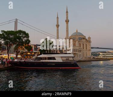 Luxusyacht an der Uferpromenade des Bosporus neben der Moschee im Stadtteil Ortaköy, Bezirk Beşiktaş, Istanbul, Türkei Stockfoto