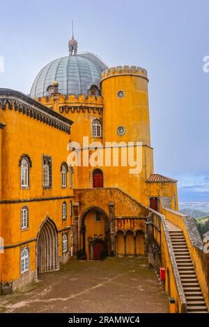 Die farbenfrohe zylindrische Bastion im Neuen Palast im Innenhof der Bögen des Palastes Pena oder die historische Burg Palácio da Pena in Sintra, Portugal. Das Märchenschloss gilt als eines der schönsten Beispiele der portugiesischen Romantik aus dem 19. Jahrhundert der Welt. Stockfoto