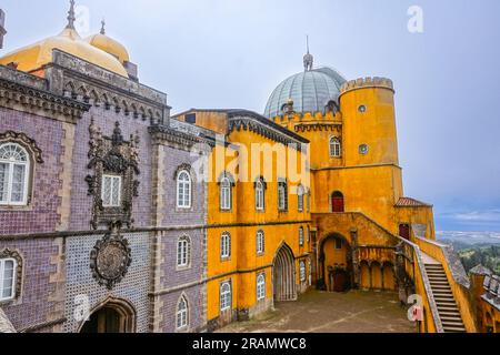 Die farbenfrohe zylindrische Bastion im Neuen Palast im Innenhof der Bögen des Palastes Pena oder die historische Burg Palácio da Pena in Sintra, Portugal. Das Märchenschloss gilt als eines der schönsten Beispiele der portugiesischen Romantik aus dem 19. Jahrhundert der Welt. Stockfoto